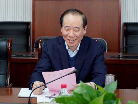 桌子前坐着穿蓝色衣服的人中度可信度描述已自动生成